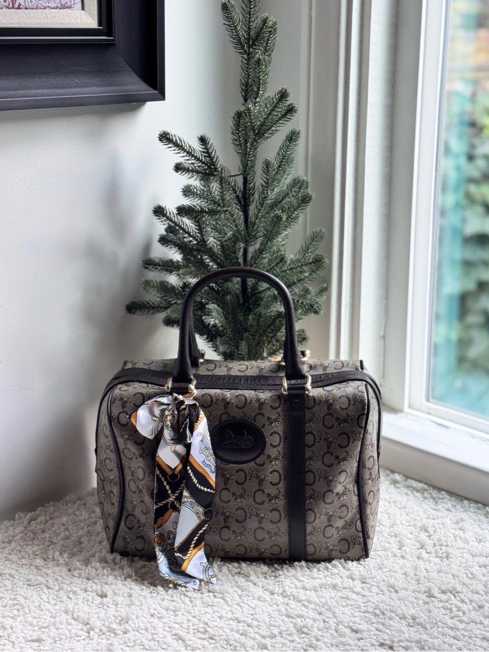 Celine Boston bag features the iconic Macadam monogram pattern and leather trim.